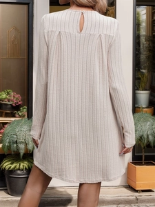 Dettaglio del retro di un abito beige in maglia a coste con chiusura a bottone e pieghe