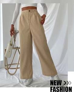 Detail of khaki corduroy texture on high-waisted wide-leg trousers with front button