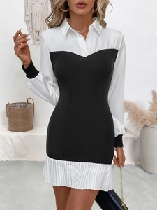 Detail of contrast lapel collar and pleated hem on a slim black and white dress