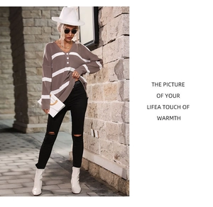 Detail of V-neck striped knit sweater with three white decorative buttons on the collar