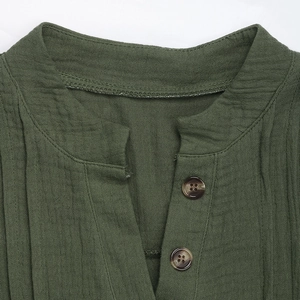 Dettaglio camicia verde militare in cotone lino con scollo a V e bottoni in resina ambra