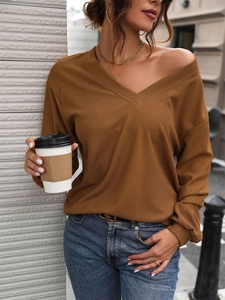 Détail du tissu gaufré caramel et de l'encolure en V sur un t-shirt à manches longues