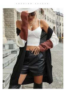Détail du cardigan en maille avec blocs de couleurs contrastées noir, blanc et rouille