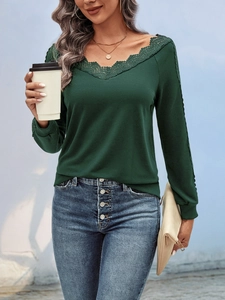 Detail of dark green V-neck long sleeve top with delicate lace trim and elastic cuffs