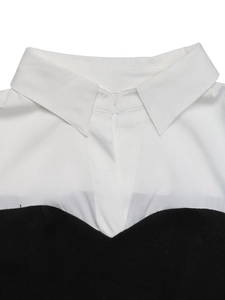 Detailed view of black and white contrast shirt collar with V-neckline patchwork design
