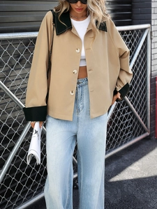 Detail of khaki cropped cardigan with black contrast collar and buttons in street setting