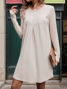 Dettaglio dell'abito in maglia a coste beige con cucitura a V e pieghe arricciate