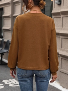 Détail de la texture gaufre marron sur le t-shirt ample à manches longues en V