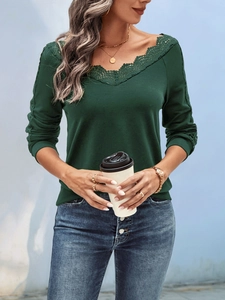 Detail of elegant V-neckline with lace trim on a dark green long-sleeve knit top