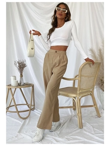 Detail view of high-waist khaki corduroy wide-leg pants paired with white sneakers