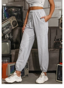 Detailed view of light grey high-waist joggers with elastic waistband and drawstring detail