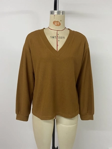 Détail de l'encolure en V et du tissu gaufré sur ce haut à manches longues couleur caramel