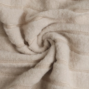 Dettaglio del tessuto a maglia a coste beige con morbida trama mohair per abiti invernali