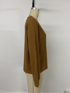 Vue détaillée du tissu gaufré marron sur un haut à manches longues avec col en V
