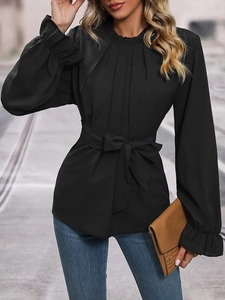 Detail of elegant black long sleeve shirt with lace collar and waist tie belt