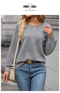 Detail shot of the grey knit sweater showing intricate geometric textured patterns