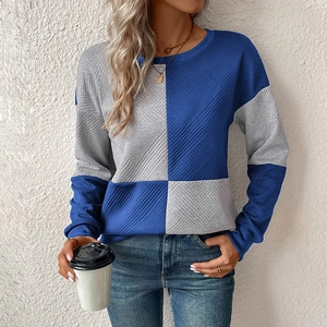 Close-up of color-block knit sweatshirt with textured diamond patterns and crewneck