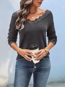Detail of elegant black long-sleeve V-neck top with lace trim and casual styling