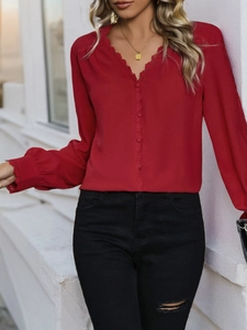 Detail of red V-neck blouse featuring delicate lace trim and decorative buttons