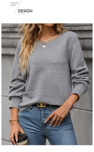 Close-up of gray textured knit sweatshirt featuring a detailed geometric relief pattern