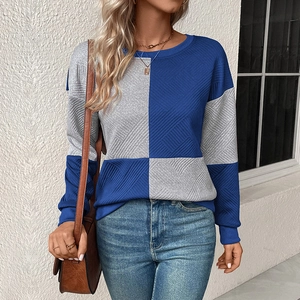Detail of blue and grey checkerboard knit sweater showing textured diagonal stitch texture