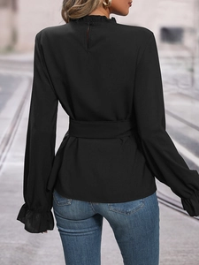 Detail view of black long sleeve blouse showing back keyhole closure and ruffle stand collar