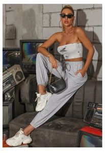 Detail of high waist joggers with elastic drawstring and white tie-dye bandeau top