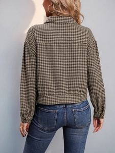 Detail view of the back of a vintage brown houndstooth plaid cropped jacket with long sleeves