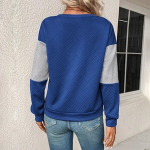 Close-up of the textured geometric knit fabric and contrast stitching on the back sleeves