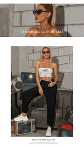 Detail of white tie-dye tube top and black joggers in a retro industrial setting