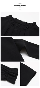 Detail view of black blouse featuring ruffled collar and pleated cuffs on chiffon fabric