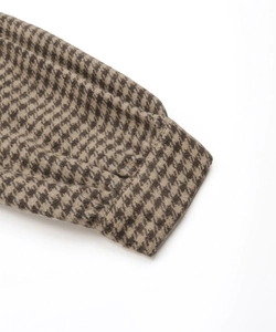 Detailed close-up of dark brown and beige houndstooth wool fabric on sleeve cuffs