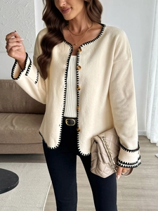 Close-up of contrast stitch edging and round buttons on off-white fleece jacket