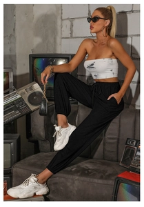 Detail of high waisted black jogger pants with adjustable drawstring and side pockets
