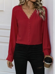 Detail of red V-neck long sleeve shirt featuring delicate lace trim and fabric buttons