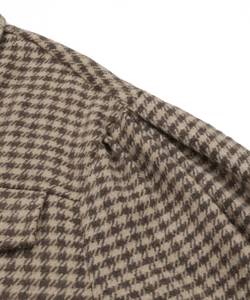 Detail of the vintage brown houndstooth jacket featuring a classic collar and flap pocket