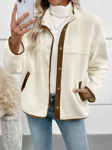 Detail of cream polar fleece jacket with brown trim and snap button closure