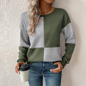 Detail of long sleeve pullover with color-block stitching and quilted texture fabric