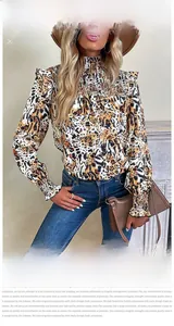 Close-up of leopard print blouse featuring ruffled high neck and tiered sleeve details