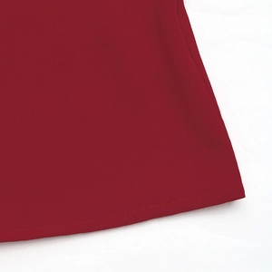 Detailed macro view of the crimson red blouse hem showing high-quality stitching and fabric