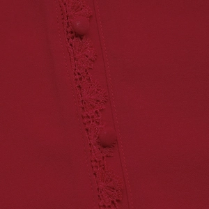 Detailed close-up of dark red shirt featuring lace trim and fabric-covered buttons