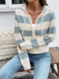 Detail van gebreid vest met capuchon en strepen in lichtblauw en beige met rits detail