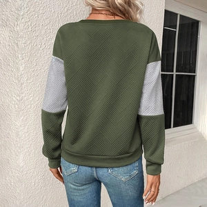 Detail of army green and grey patchwork sweatshirt with geometric textured knit fabric