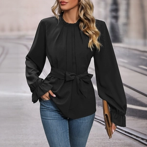 Elegant black long sleeve blouse with ruffle neck and waist tie-up detail in urban setting
