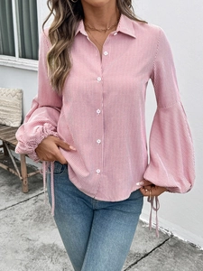 Close-up of red and white striped shirt with puff lantern sleeves and tie cuffs