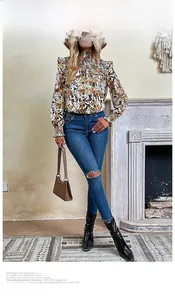 Detail of high neck leopard print blouse styled with blue distressed jeans and black boots