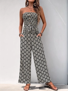 Close-up of strapless jumpsuit featuring black and white ethnic print and waist tie