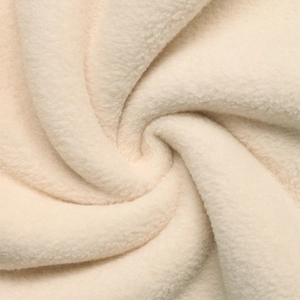 Close-up of cream polar fleece texture showing thick soft fibers and warm plush material
