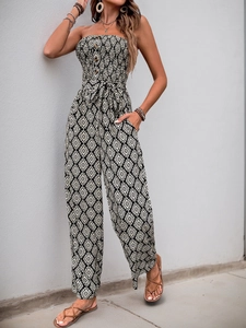 Detail of smocked strapless jumpsuit with monochrome geometric print and waist tie belt