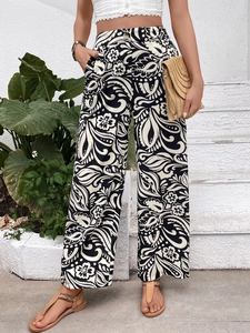 Detail of high-waisted wide-leg trousers with black and white paisley floral print